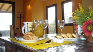 A breakfast table with croissants, a coffee cup, and a pitcher of juice. - Aurora dell'Etna (Zafferana Etnea)