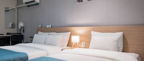 A hotel room with two beds, a desk with a chair, a mirror, an air conditioning unit, and a painting on the wall.