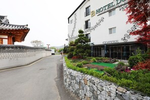 A traditional Korean-style building with a stone wall and a modern coffee shop on the ground floor. - Suwon Dono1796 Hotel (Suwon)
