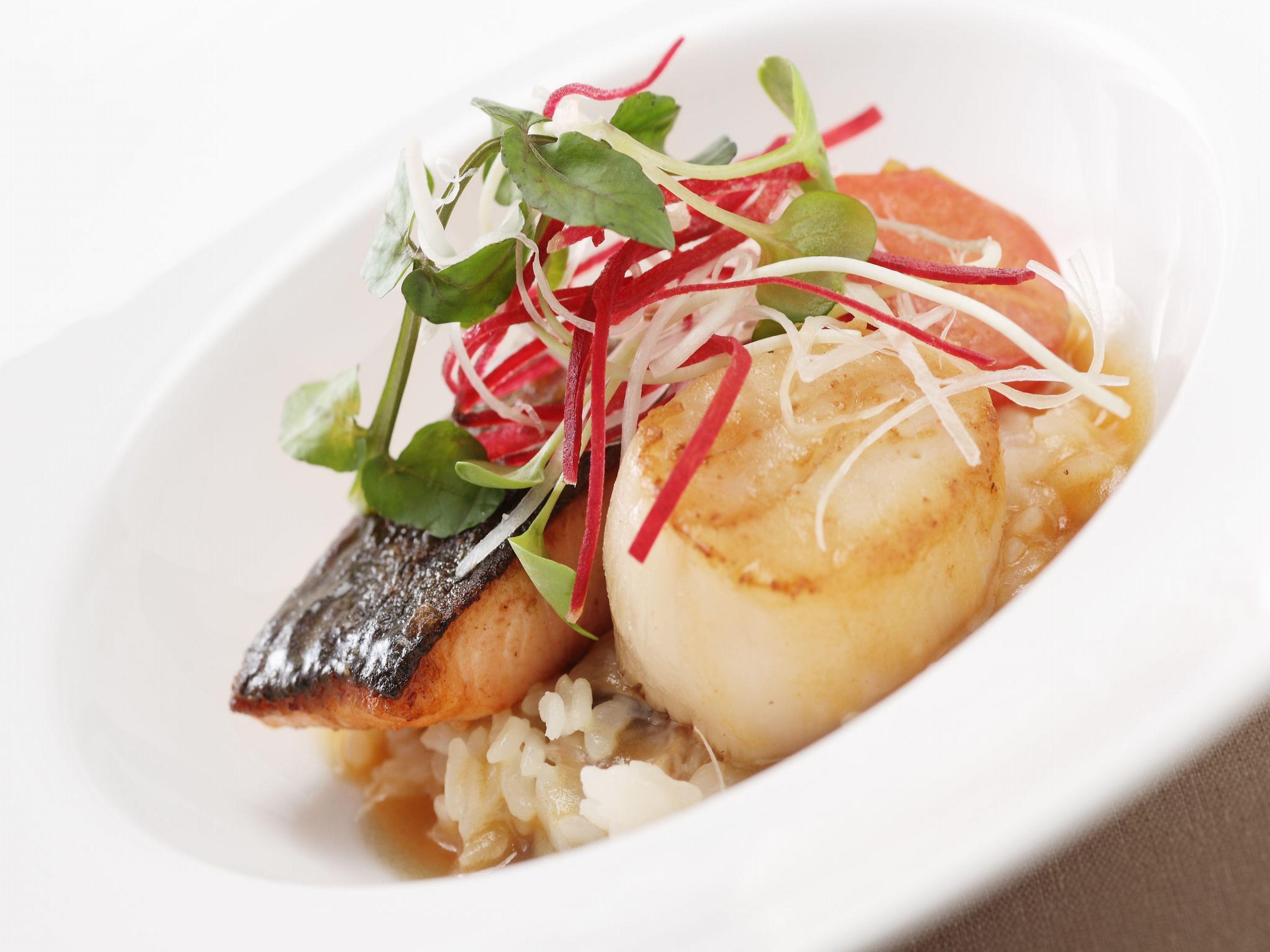 Ein Gericht mit Fisch, Reis und Beilagen.
