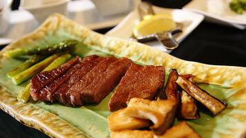 Un plato de comida con carne a la parrilla, espárragos y patatas asadas.