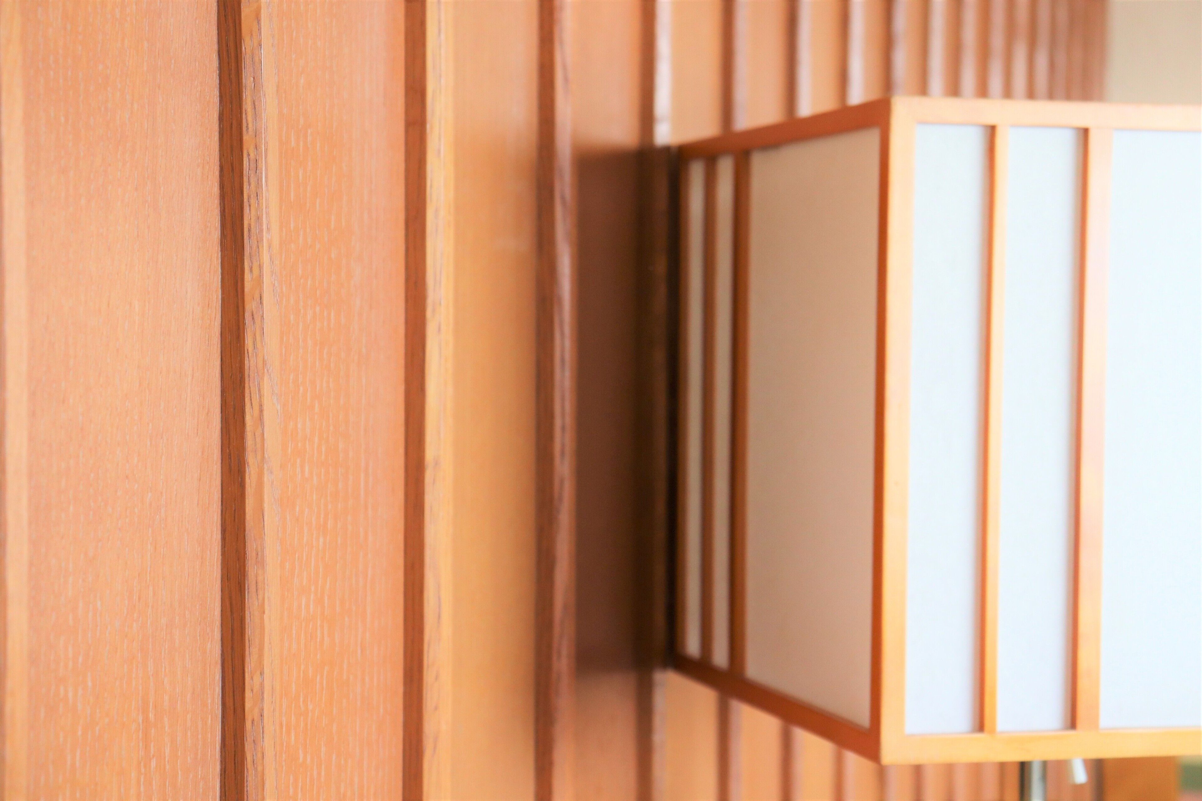 A close-up of a wooden wall with vertical slats and a framed object.