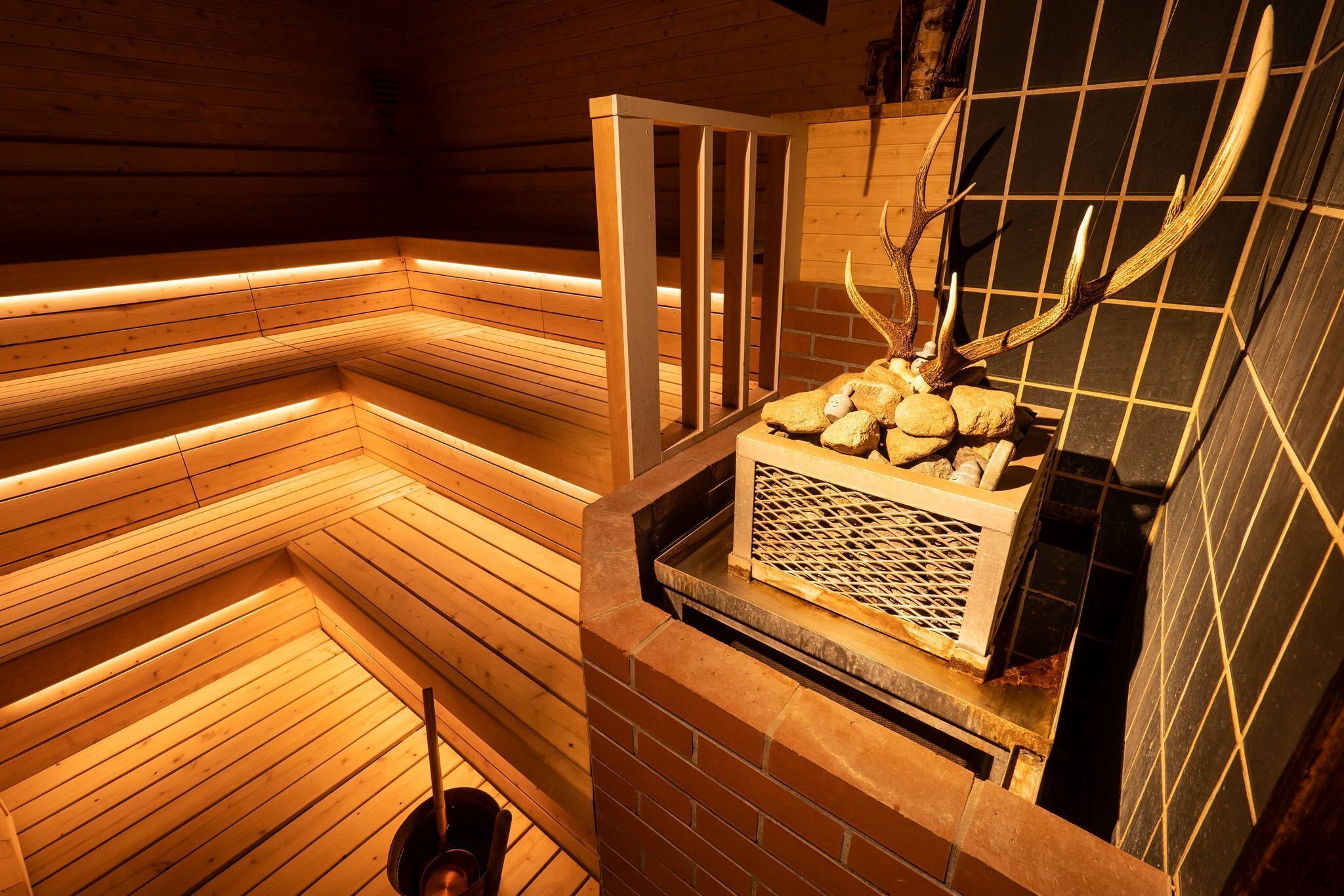 A sauna with wooden benches and a tiled wall.
