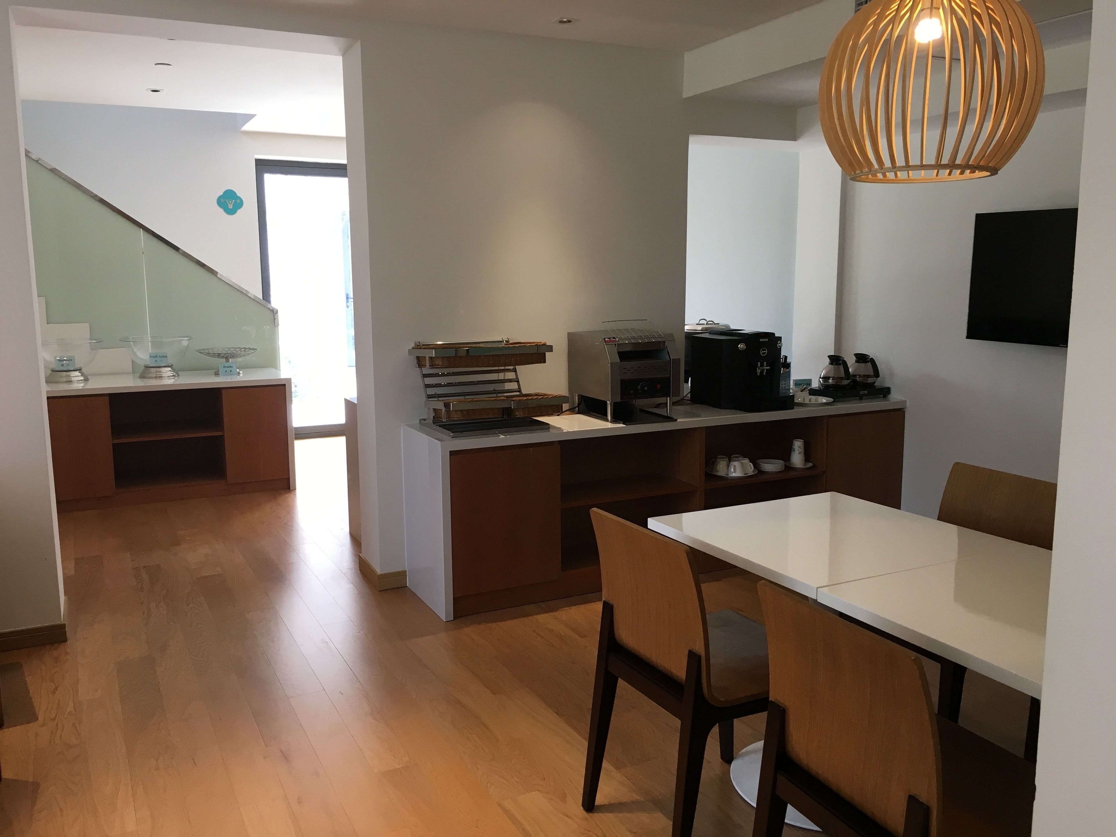 Una cocina moderna con comedor, piso de madera y una escalera que lleva a otra habitación.