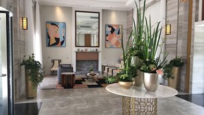A modern lobby with a marble floor, a central round table with a gold base, and potted plants. - Green Court Place Jinqiao Middle Ring Shanghai (Shanghai)