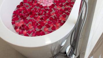 A bathtub filled with rose petals.