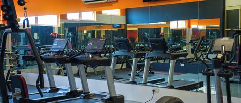 A gym with treadmills, exercise bikes, and weights.