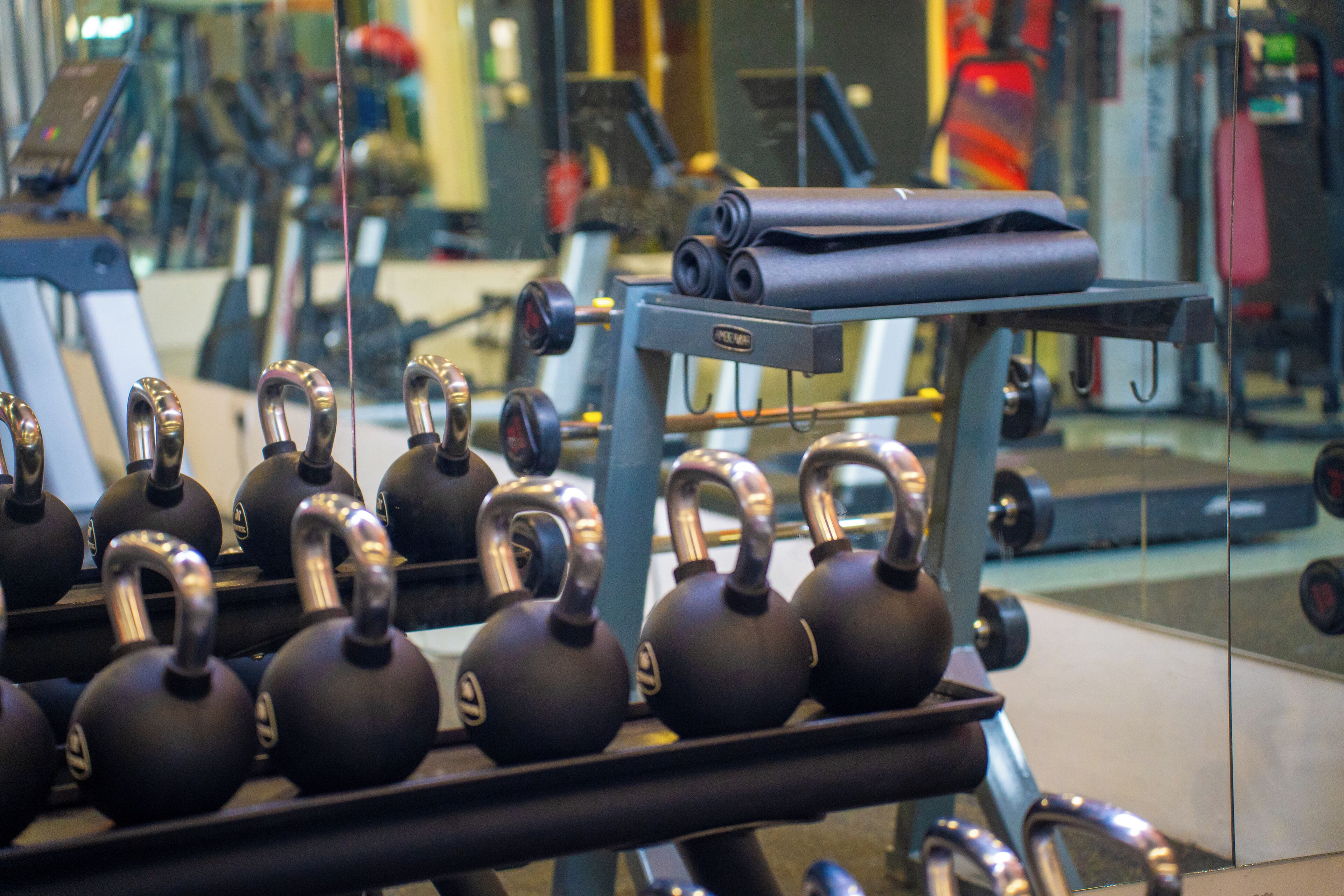 A gym with kettlebells, a bench, and exercise equipment.