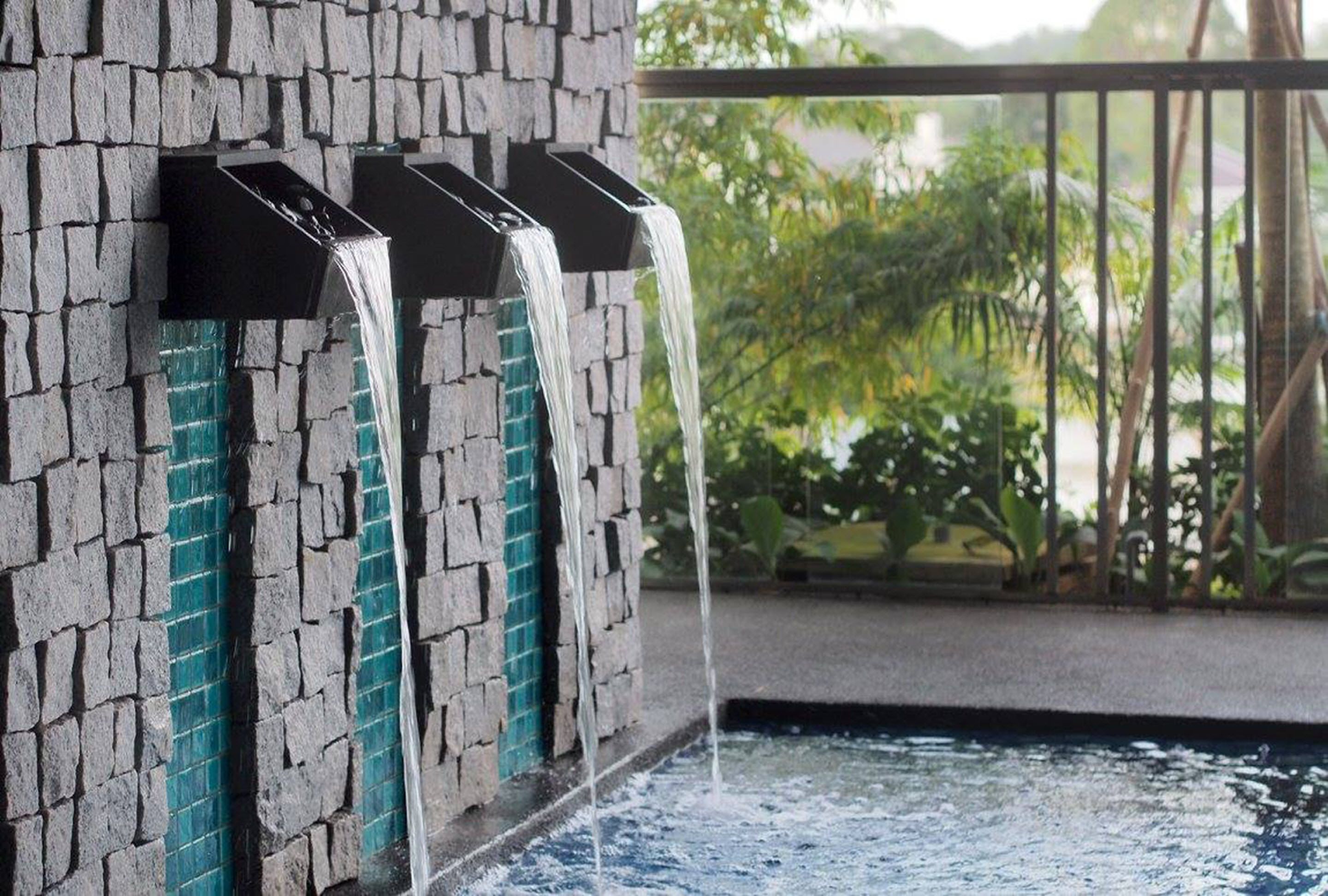 Un muro di pietra con tre giochi d'acqua.