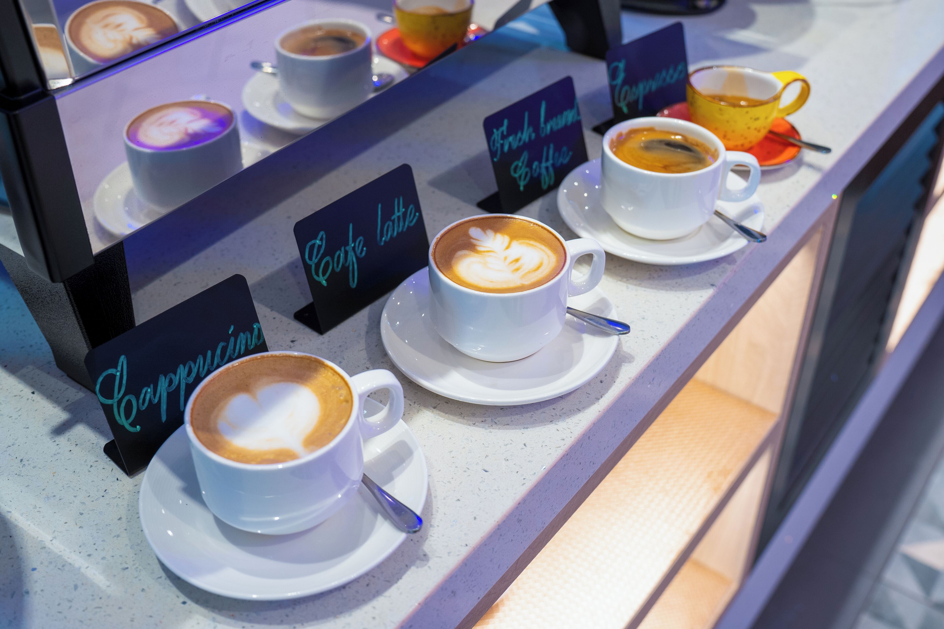 Una presentación de café con diversos tipos de bebidas, como cappuccino y latte, servidas en tazas blancas con platillos.