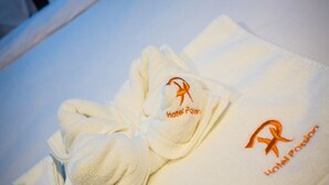 Een witte handdoek met het borduurwerk van de Hotel Passion logo en naam.
