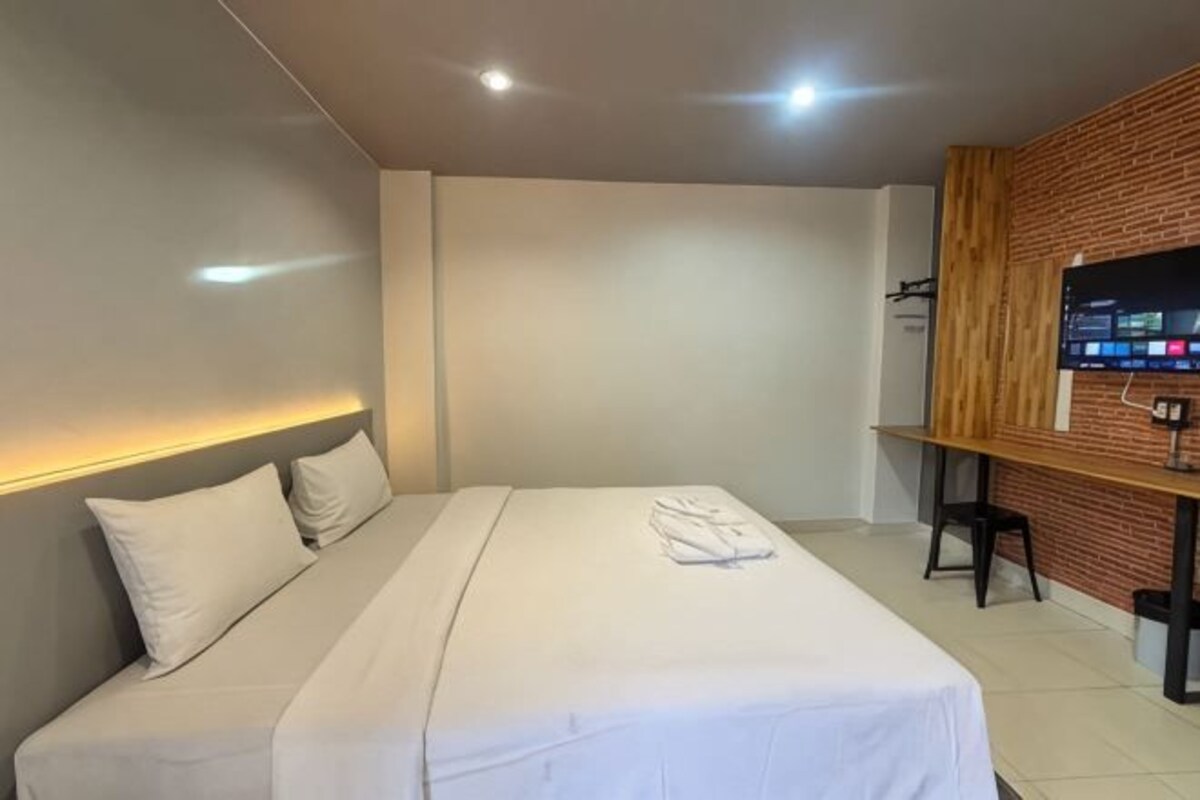 Une chambre d’hôtel avec un lit, un bureau et une télévision.