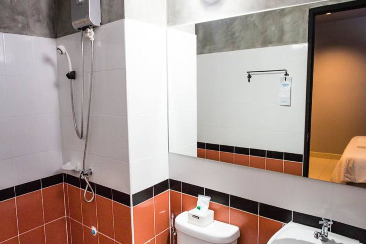 Ein Badezimmer mit Dusche, Toilette, Waschbecken und Spiegel.