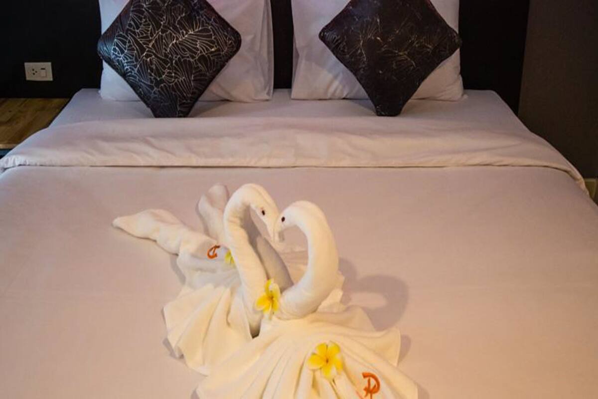 Ein Bett mit weißen Bettwäsche und zwei Zierkissen.