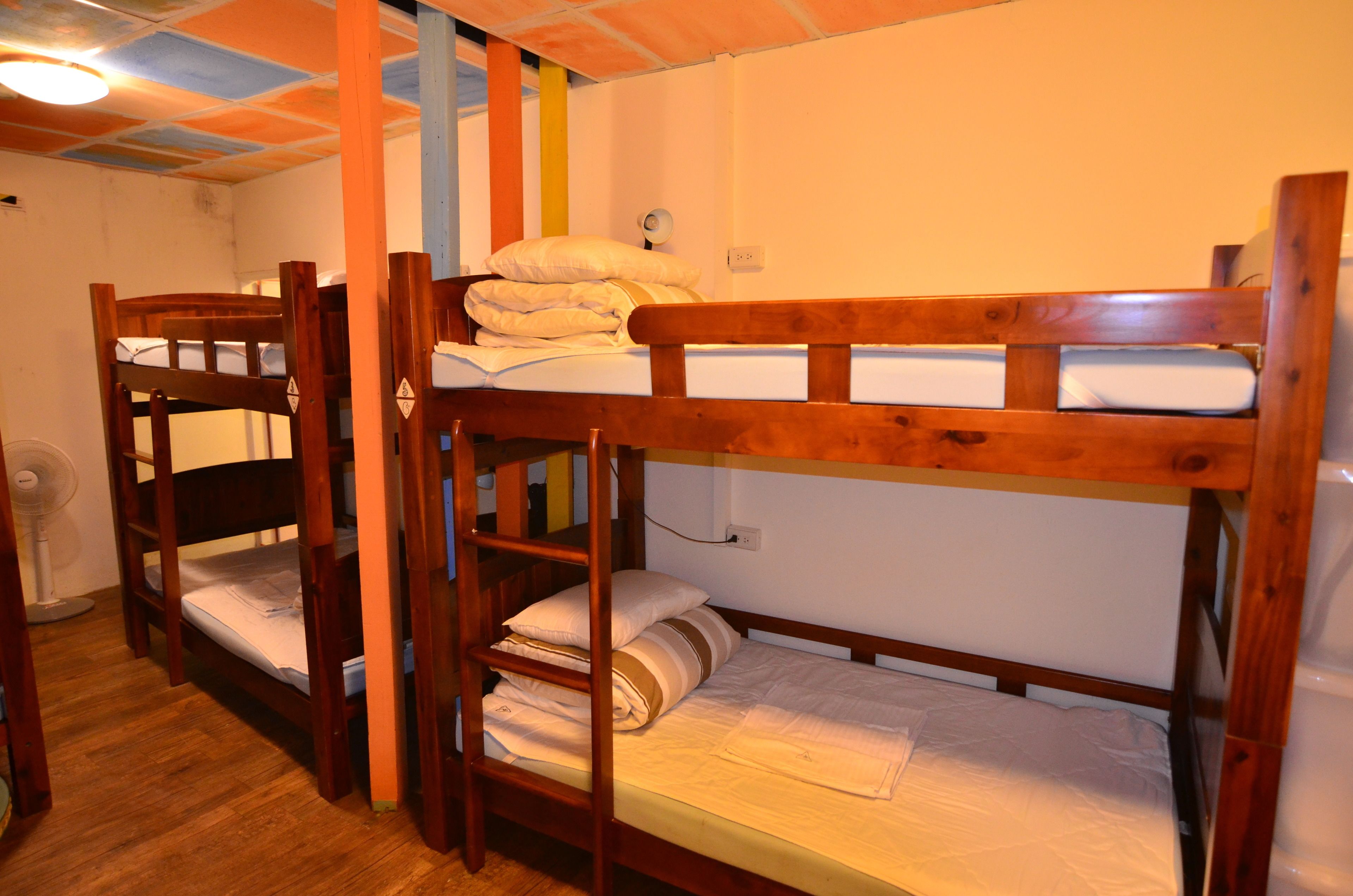 A bunk bed room with wooden frames and white bedding.