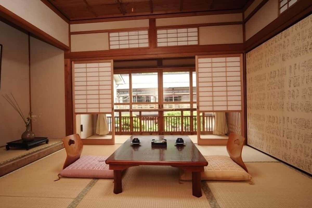 Une pièce de style japonais traditionnel, avec un sol recouvert de tatamis, une basse table en bois et des portes coulissantes en papier de riz (shoji).