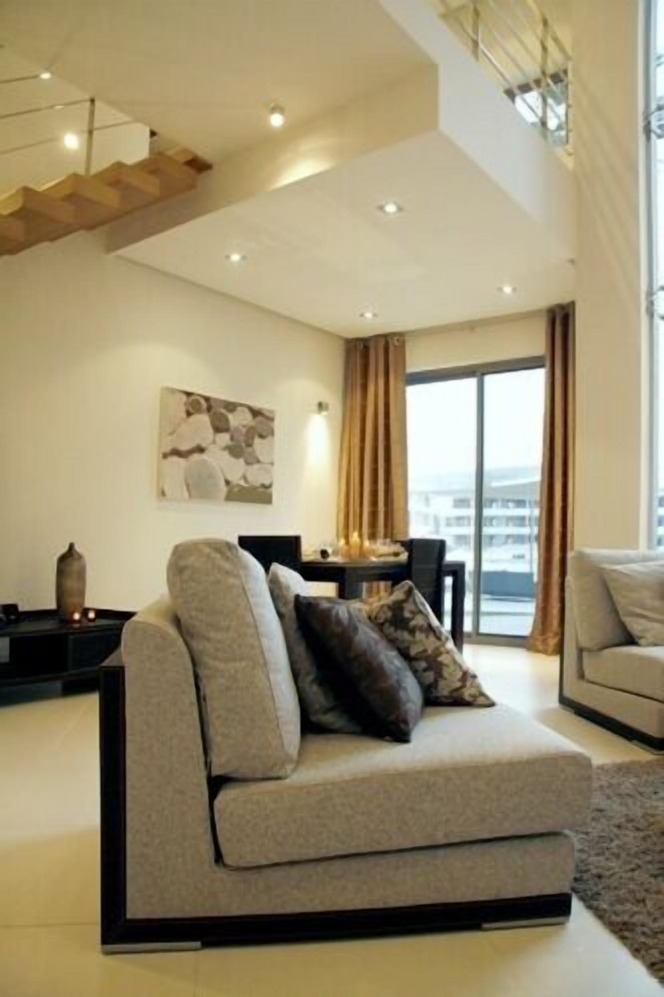 Een moderne woonkamer met een bank, een tafel en een schilderij aan de muur.