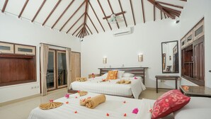 A hotel room with two beds, a large mirror, and a ceiling fan. - Martas Hotel Gili Trawangan (Gili Trawangan)