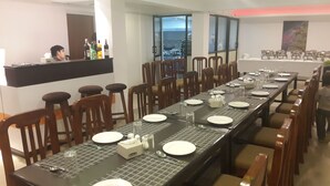 Una larga mesa de comedor lista para una comida, con sillas alrededor.