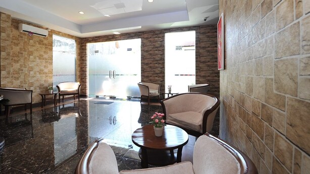 A modern lobby with stone walls, a marble floor, and comfortable seating areas. - Amaya Suites (Pogung Lor)