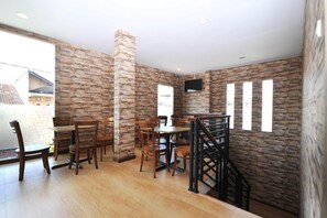 A dining area with wooden furniture and a stone wall.