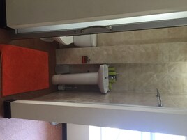 A bathroom with a toilet, sink, and a towel rack.
