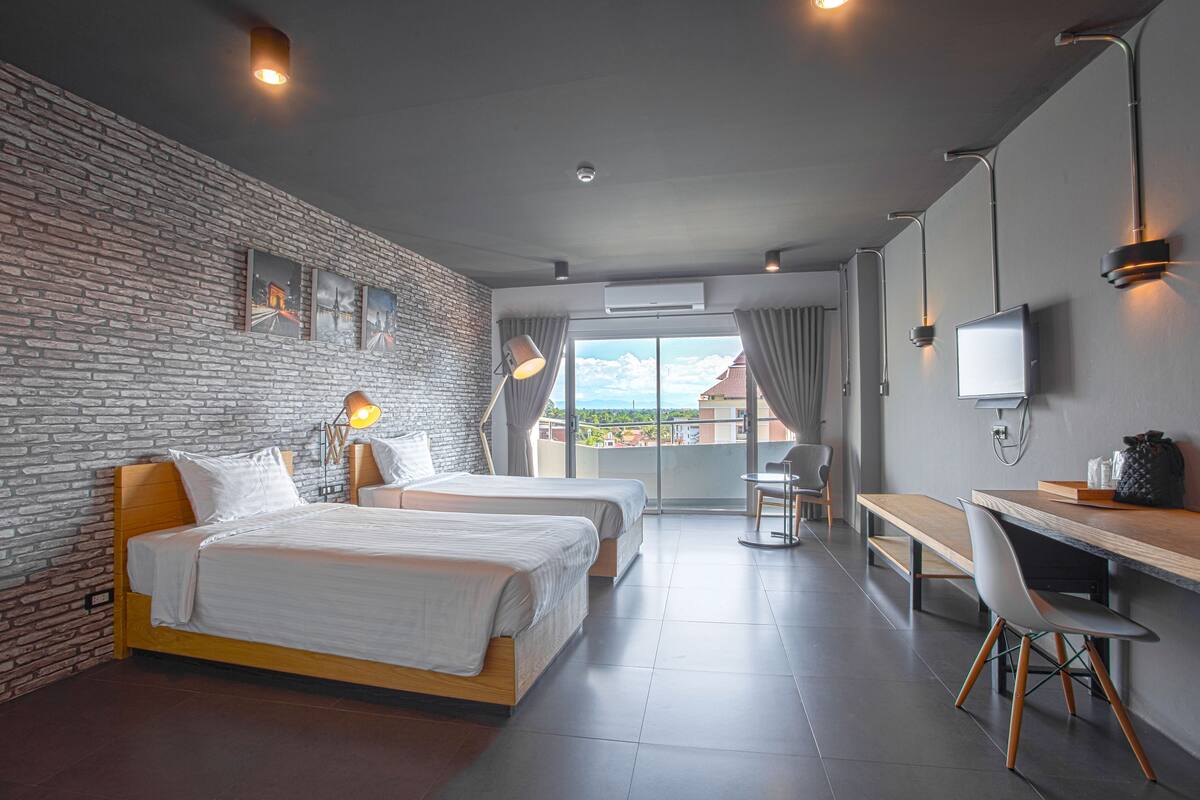 Een moderne hotelkamer met twee bedden, een bureau, een stoel en een televisie.