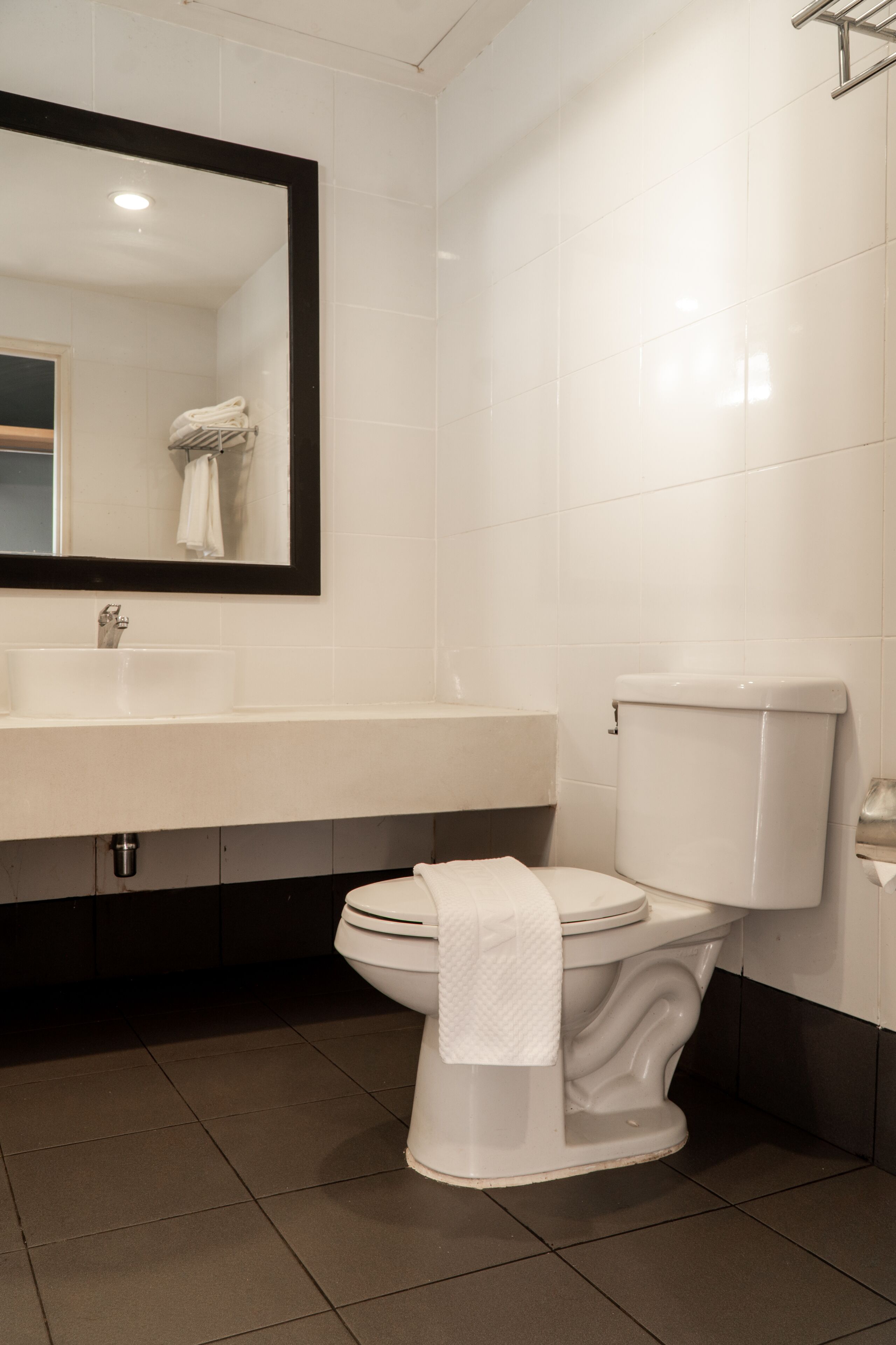 A bathroom with a white sink, a toilet, and a mirror.