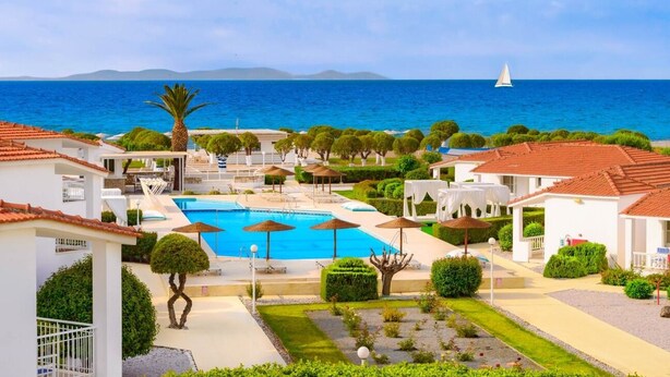 A resort with a swimming pool, lounge areas, and a view of the sea. - Fito Aqua Bleu Resort (Samos)