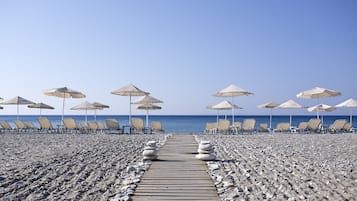 På stranden, solsenger og parasoller