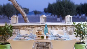 A table set for two with a view of the sea, stone walls, and potted plants. - Fito Aqua Bleu Resort (Samos)