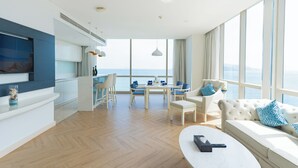 A modern living room with a sofa, coffee table, and dining area. - Diamond Bay Hotel (Nha Trang)