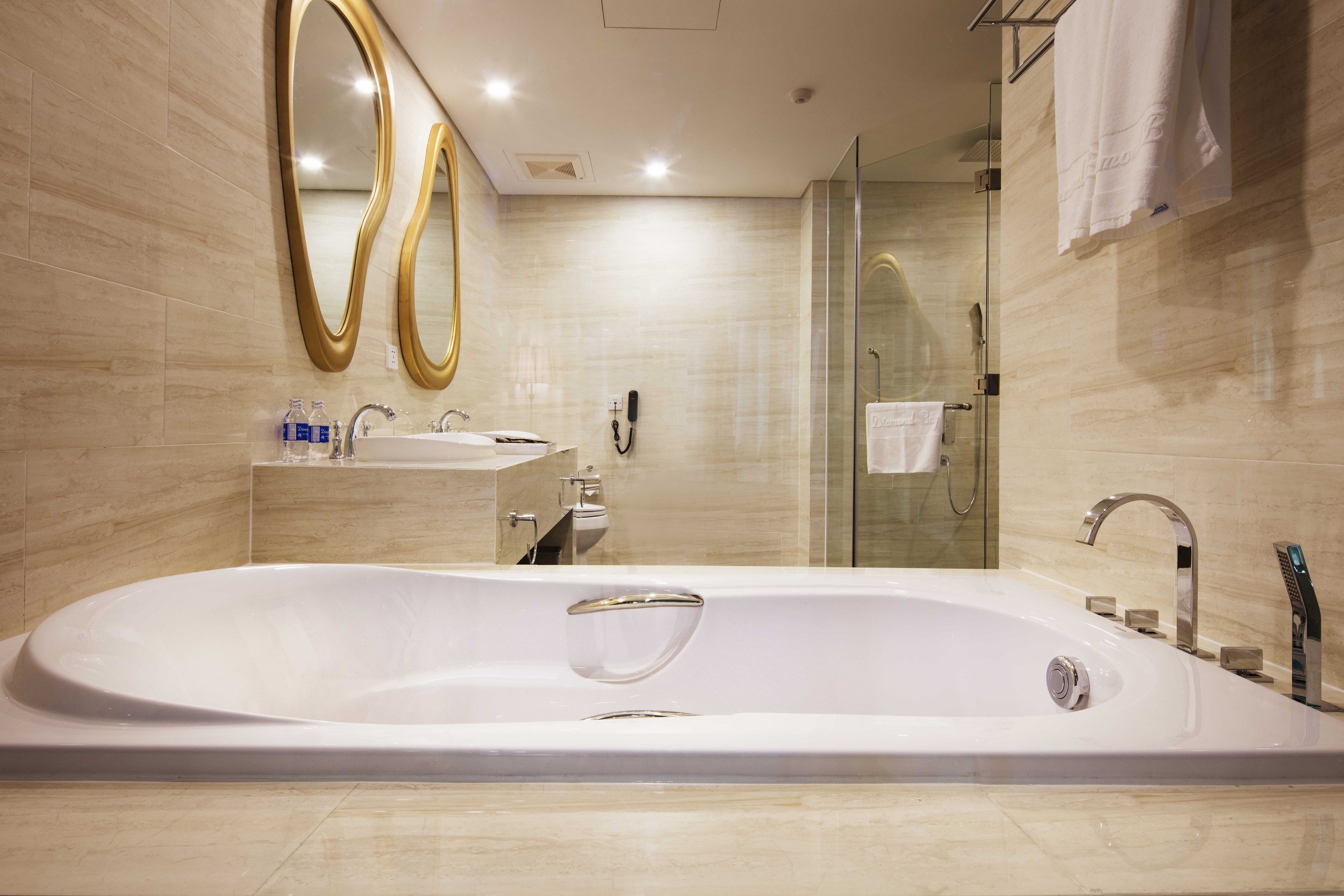 Un bagno moderno con una vasca da bagno spaziosa, una cabina doccia in vetro e un mobile lavabo con specchio.