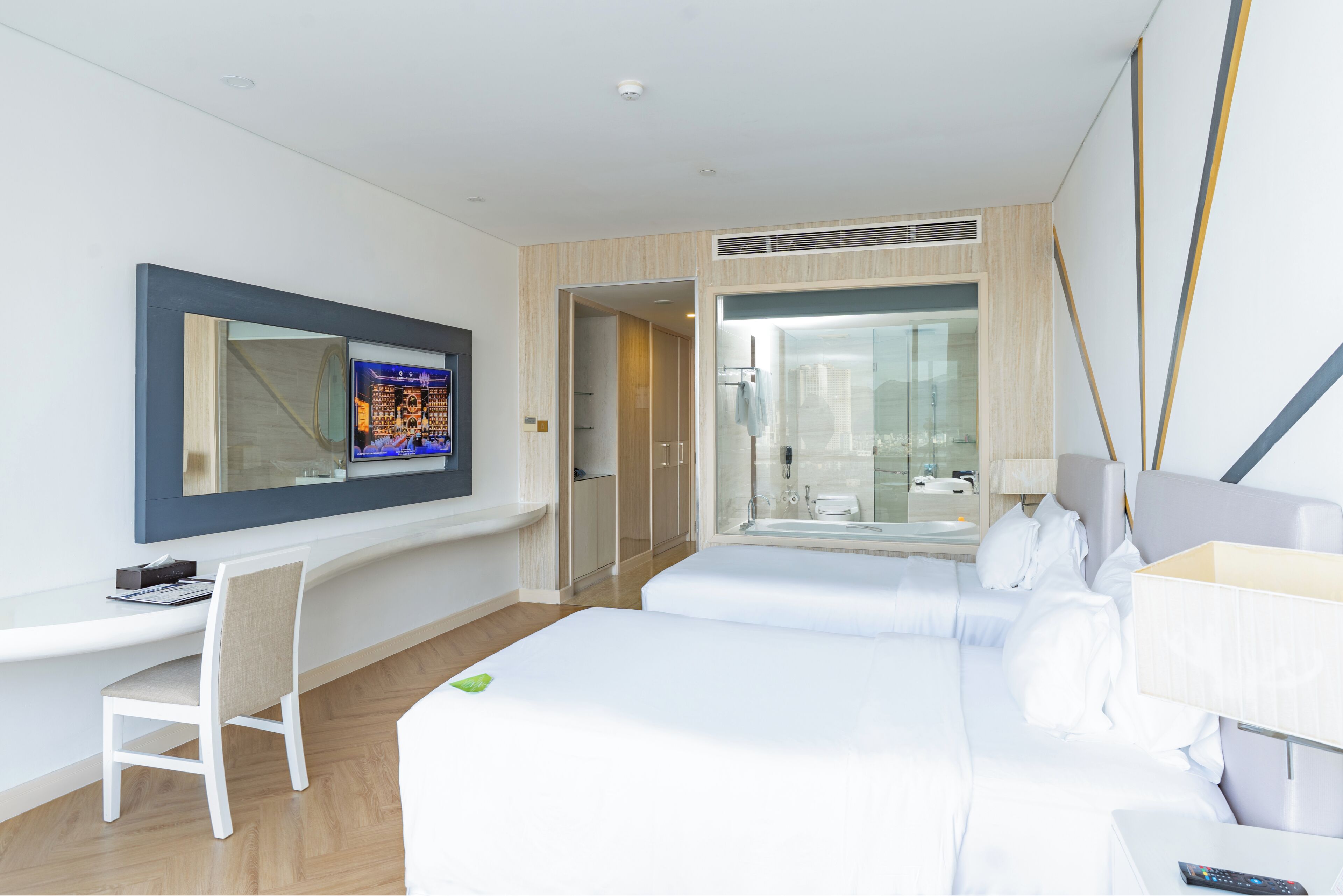 Une chambre d’hôtel comprenant un lit, un bureau, une chaise, une télévision et une salle de bain.