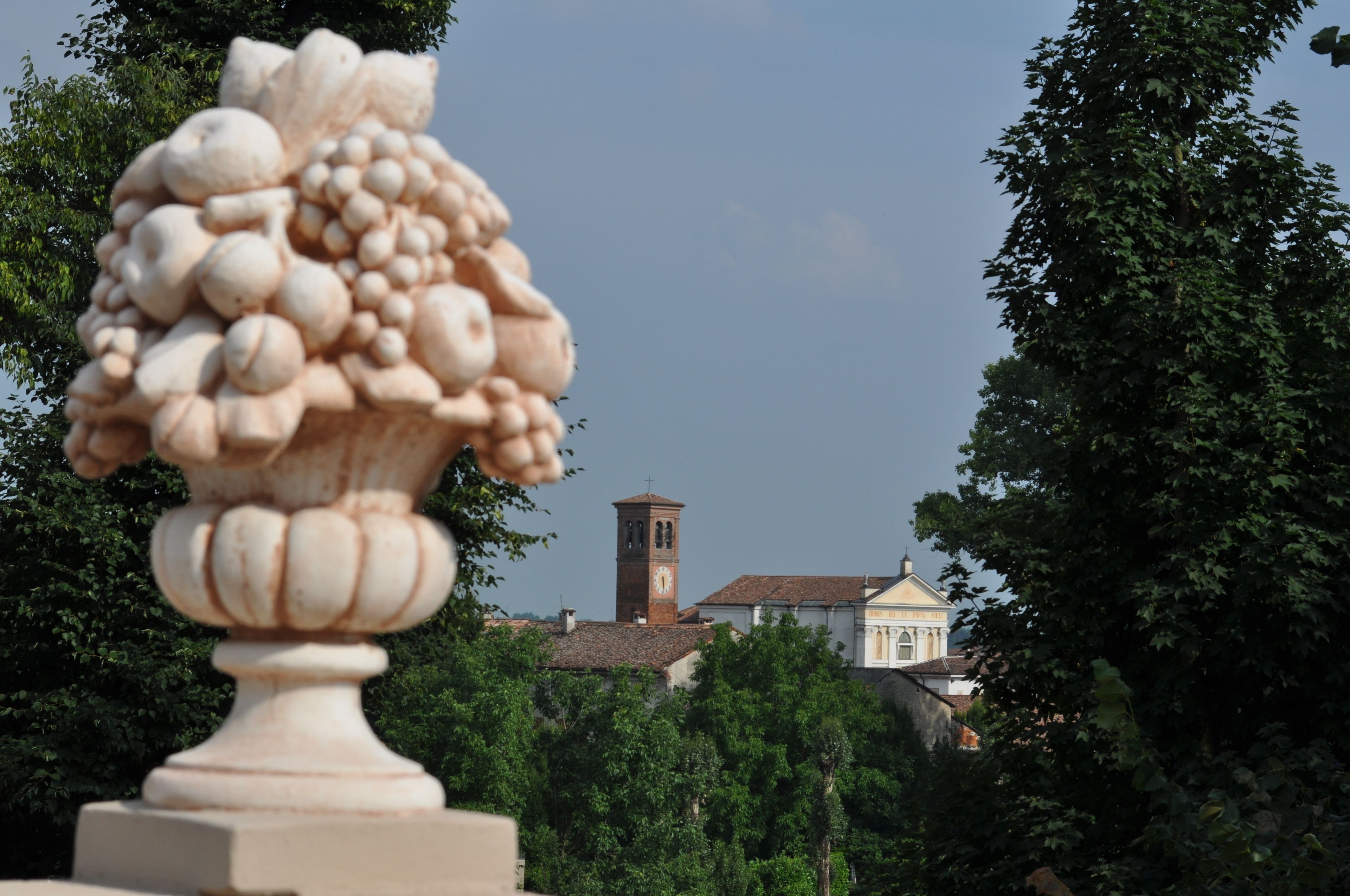 A stone urn with a floral design in a garden setting.