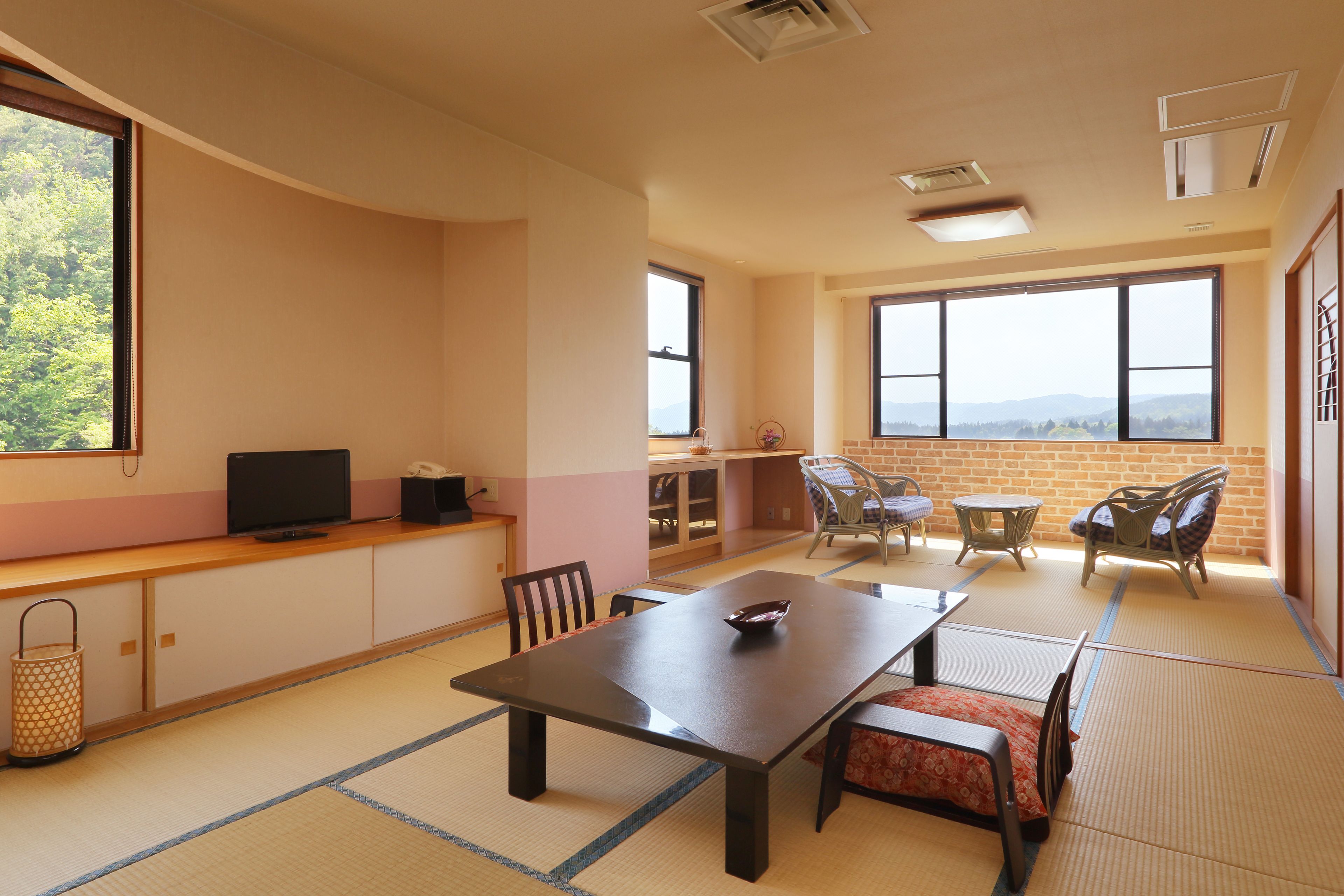 A traditional Japanese-style room with tatami flooring, a low table, and a sofa.