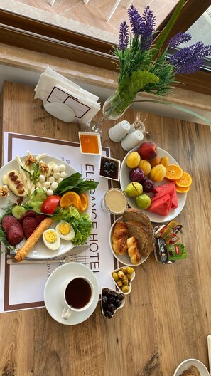 A breakfast buffet with various fruits, cheeses, and pastries on a wooden table. - Elegance Hotel Kemer (Kemer)