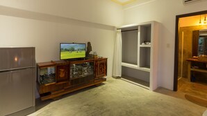A modern living room with a flat-screen TV, wooden cabinet, and a large window. - Blue Beach Village Homestay (Da Nang)