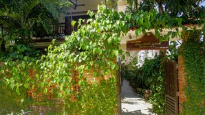 A gated entrance with a sign for 'Blue Beach Village' and a pathway leading to a building. - Blue Beach Village Homestay (Da Nang)