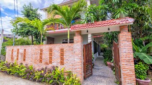 A house with a brick wall, a wooden gate, and a tiled roof. - Blue Beach Village Homestay (Da Nang)