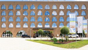 A hotel with a symmetrical facade, multiple arched windows, and a clear entrance. - Hotel Tobbaccon (Bensheim)