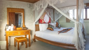 A bedroom with a wooden bed, a nightstand, a mirror, and a decorative wall hanging. - M Y Home Hotel (Chiang Mai)