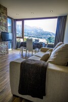 Una sala de estar moderna con un sofá, una televisión y un comedor con una mesa y sillas.