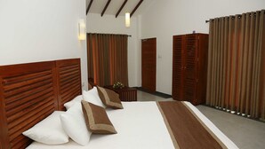 Une chambre d’hôtel avec un grand lit, une tête de lit en bois et un coussin décoratif marron.