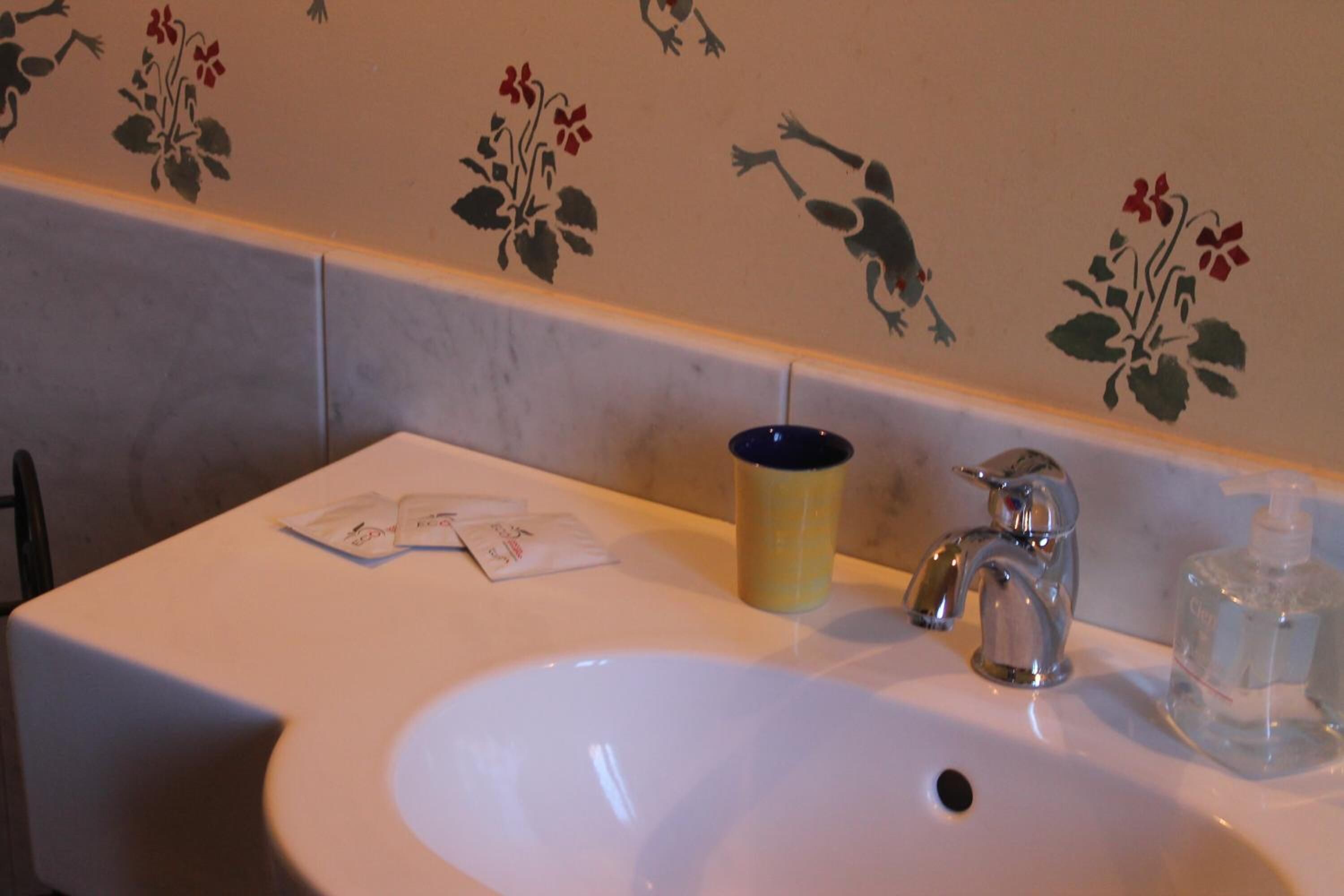 A bathroom sink with a faucet, a tissue box, and a soap dispenser.