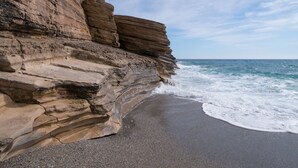 Un acantilado costero con una playa de arena y olas del océano.