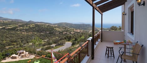 A balcony with a view of a valley and a river.