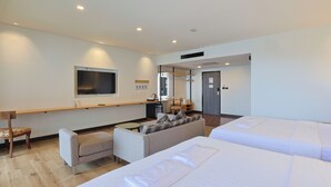 A hotel room with a large bed, a sofa, a TV, and a desk with a chair. - The Royal River Hotel (Bangkok)