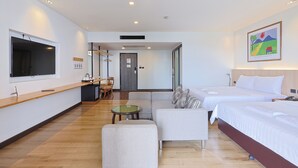 A hotel room with two beds, a sofa, a small table, and a TV. - The Royal River Hotel (Bangkok)