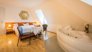 Un dormitorio moderno con cama, mesita de noche, silla y una bañera grande.